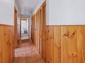A hallway with wooden closets and tile flooring at Hawksie Place in Reporaa
