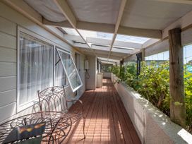 An outdoor terrace with a table and chairs at Hawksie Place in Reporoa