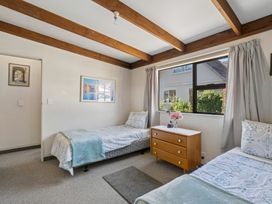 A bedroom with two beds and a dresser at Wanaka Holiday Home in Wanaka