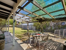 An outdoor garden with a table and chairs under a pergola at Wanaka Holiday Home in Wanaka