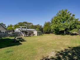 A garden with a picnic table and shed at Wanaka Holiday Home in Wanaka