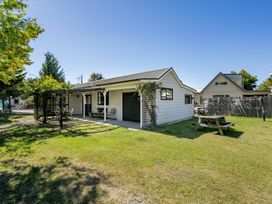A house with garden furniture and trees at Wanaka Holiday Home in Wanaka