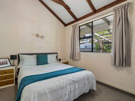 A bedroom with a bed and bedside lamp at Wanaka Holiday Home in Wanaka