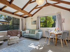 A living room with a dining area and a sofa at Wanaka Holiday Home Wanaka