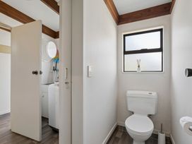 A bathroom with a toilet and a washing machine at Wanaka Holiday Home in Wanaka