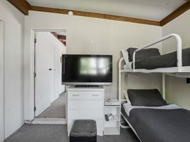 A bedroom with a bunk bed and television at Wanaka Holiday Home in Wanaka