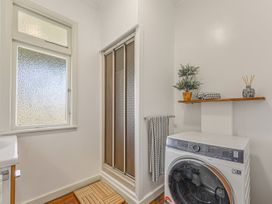 A laundry room with a washer and shower at Kettle House - Upper Moutere Holiday Home