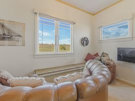 A snug with windows and a sofa at Kettle House - Upper Moutere Holiday Home