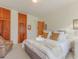 A bedroom with a bed and nightstand at Kettle House - Upper Moutere Holiday Home