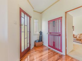 An entryway with a front door and coat hooks at Kettle House - Upper Moutere Holiday Home