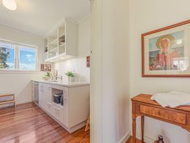 A kitchen with cabinets and a table at Kettle House - Upper Moutere Holiday Home