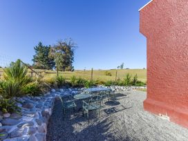 A table and chairs in an outdoor area at Kettle House - Upper Moutere Holiday Home