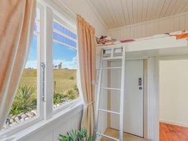 A bedroom with a loft bed and ladder at Kettle House - Upper Moutere Holiday Home