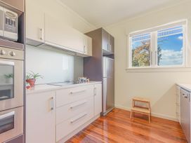 A kitchen with a refrigerator and sink at Kettle House - Upper Moutere Holiday Home