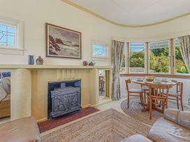 A living room with a fireplace and dining table at Kettle House - Upper Moutere Holiday Home