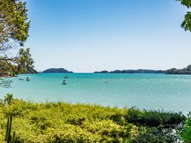 A view of water with boats and islands at Parekura Bay in Hikurangi