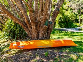 A kayak leaning against a tree in Parekura Bay Hikurangi