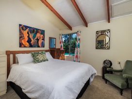 A bedroom with a bed and window at Parekura Bay in Hikurangi