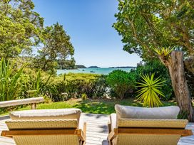 A deck with lounge chairs overlooking the water at Parekura Bay in Hikurangi