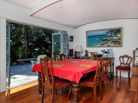 A dining room with a table and chairs at Parekura Bay Hikurangi