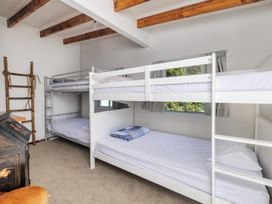 A bedroom with bunk beds and a window at Parekura Bay in Hikurangi