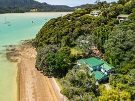 An aerial view of a beach and houses at Parekura Bay in Hikurangi
