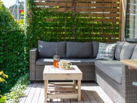 An outdoor lounge area with a sofa and a coffee table at River Cottage - Whitianga Holiday Home Whitianga