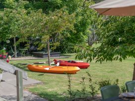 Kayaks on grass near trees at River Cottage - Whitianga Holiday Home Whitianga