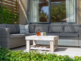 An outdoor seating area with a sofa, table, and tea set at River Cottage - Whitianga Holiday Home in Whitianga