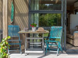 An outdoor area with a table and chairs at River Cottage - Whitianga Holiday Home Whitianga