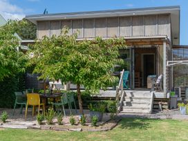 An outdoor dining area with table and chairs at River Cottage - Whitianga Holiday Home Whitianga