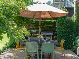 An outdoor dining area with a table and chairs at River Cottage - Whitianga Holiday Home Whitianga