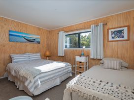 A bedroom with two beds and a window at River Cottage - Whitianga Holiday Home Whitianga