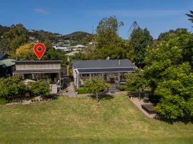 An outdoor area with two houses and greenery at River Cottage - Whitianga Holiday Home Whitianga