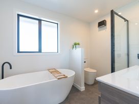 A bathroom with a bathtub, toilet, and sink at Oraka Scenery - Te Anau Holiday Home in Te Anau