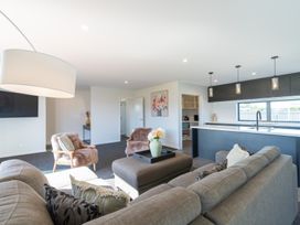 A living room with a sofa, coffee table, and lamp at Oraka Scenery - Te Anau