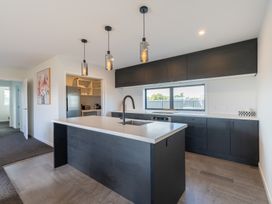 A kitchen with an island and cabinets at Oraka Scenery - Te Anau Holiday Home in Te Anau
