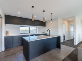 A kitchen with an island and cabinets at Oraka Scenery - Te Anau Holiday Home Te Anau
