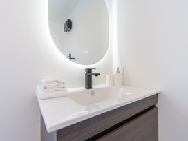 A bathroom sink with towels and a mirror at Oraka Scenery - Te Anau Holiday Home Te Anau