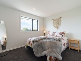 A bedroom with a bed and lamp at Oraka Scenery - Te Anau Holiday Home, Te Anau