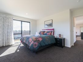 A bedroom with a bed and bedside table at Oraka Scenery - Te Anau Holiday Home, Te Anau