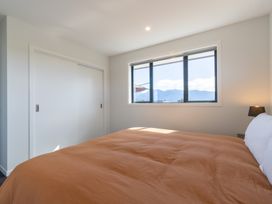A bedroom with a bed and a window at Oraka Scenery - Te Anau Holiday Home in Te Anau