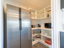 A kitchen with a refrigerator and microwave at Oraka Scenery - Te Anau Holiday Home
