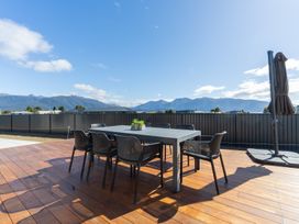 A dining area with a table and chairs on a deck at Oraka Scenery - Te Anau