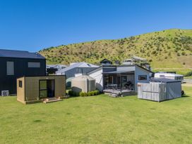 A house with a deck and wooden shed at Opito Bay Holiday Home in Opito Bay