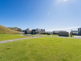 An outdoor view of houses and grass at Opito Bay Holiday Home in Opito Bay