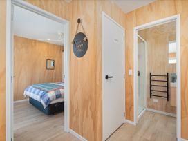A bedroom with a bed and a mirror at Opito Bay Holiday Home in Opito Bay