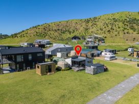 An aerial view of houses and a hill at Opito Bay Holiday Home Opito Bay