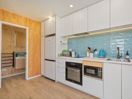 A kitchen with modern appliances and a sink at Opito Bay Holiday Home in Opito Bay