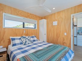 A bedroom with a bed and window at Opito Bay Holiday Home in Opito Bay